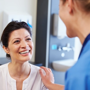 Image of a nurse and patient smiling