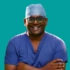 A headshot of consultant Lucky Jeyaseelan on a green background. Smiling, wearing doctors scrubs.