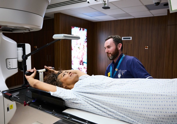 A photo of a radiologist ensuring a patient is safe whilst the linac stereotactic radiotherapy machine is in progress.