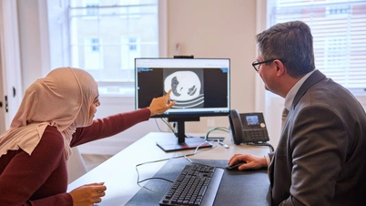 A consultant and patient looking at a scan on the screen, discussing treatment options for lung concerns