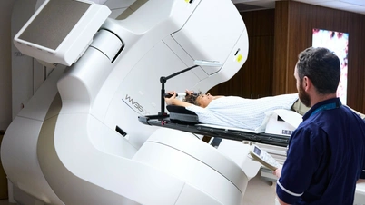 A photo of a radiologist ensuring a patient is safe whilst the linac stereotactic radiotherapy machine is in progress.