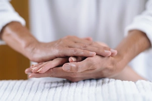 a therapist holds a patient's hand