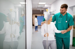 An image of a doctor helping someone down the corridor