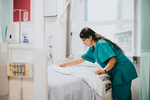 An image of a nurse making a bed