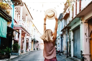 A person holds their hat in the air