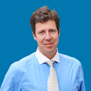 Headshot of Al Russell, CEO of The London Clinic on a blue background