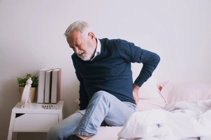 Old man with back ache clasping. Man suffering from ribbing pain or waist pain.