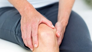 a person holds their knee