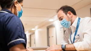 A doctor and nurse talking over a desk