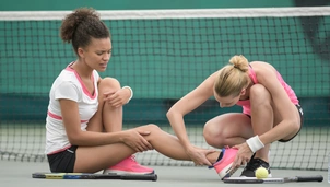 two tennis players, one with injury