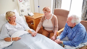 Two parents at the side of the patients bed