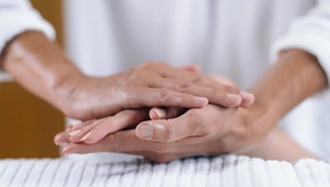 a therapist holds a patient's hand