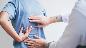 Man in back pain, doctor examining