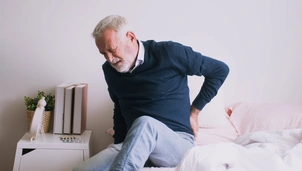 Old man with back ache clasping. Man suffering from ribbing pain or waist pain.