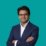 A headshot of consultant Suthesh Sivapalaratna, on a green background