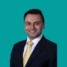 Headshot of consultant Premjit Randhawa, on a green background