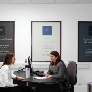 Two members of staff sitting at a desk