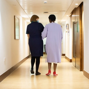 A nurse and patient walking through the corridor