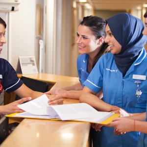 A group of nurses around a desk