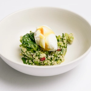 An image of a poached egg on a bed of couscous