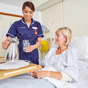 A nurse pouring a patient a glass of water