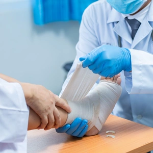 A doctor bandaging a patients foot