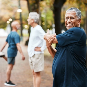 Fitness, exercise and stretching with a senior man getting ready for a workout or training outdoor at the park. Health, wellness and performance with elderly male at the start of his routine in group