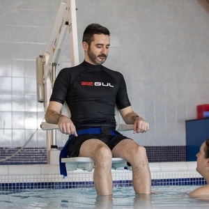 A patient being assisted into the pool with a hoist, showing accessibility of the pool