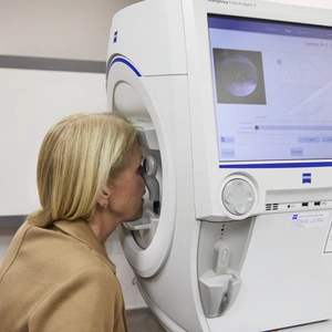 A woman receiving a visual fields eye test (diagnostic machine) at The London Clinic