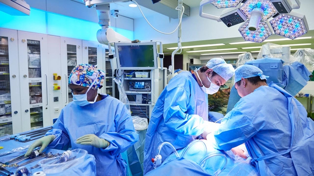 Image of three surgeons performing robotic surgery